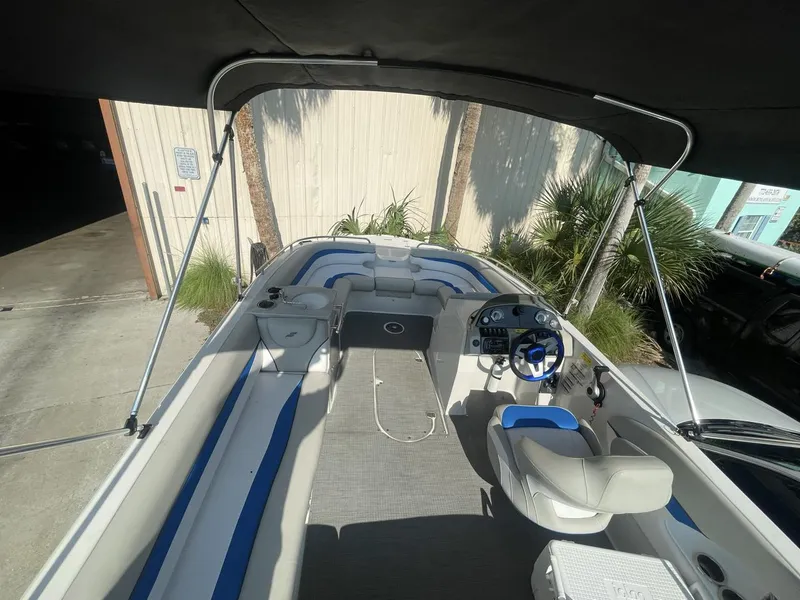 Slide: The Image of 2017 Starcraft MDX 211 O/B boat interior with blue and white seating under canopy. - 2