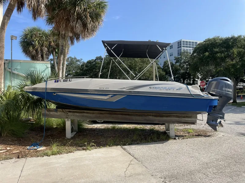 Slide: The Image of 2017 Starcraft MDX 211 O/B boat on display, blue and white, with Yamaha outboard motor. - 8