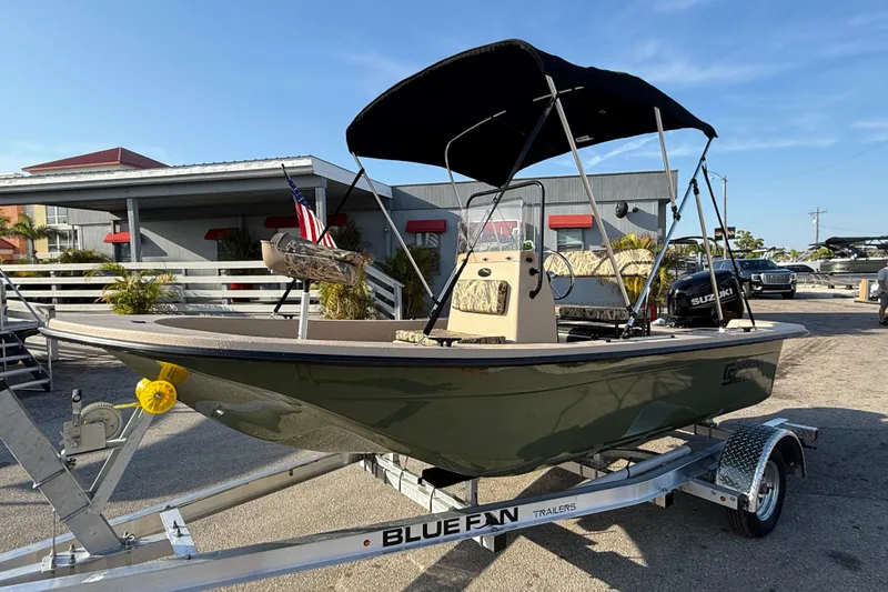 The Image of 2026 Carolina Skiff E18 JVX CC Sportsman Edition boat on trailer, outdoor display. - 1