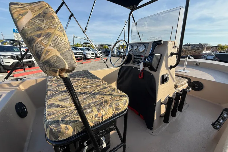 Slide: The Image of 2026 Carolina Skiff E18 JVX CC Sportsman Edition boat interior with camo seating and control panel. - 11