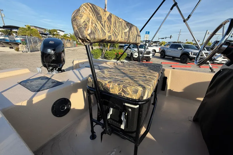 Slide: The Image of 2026 Carolina Skiff E18 JVX CC Sportsman Edition boat interior with camo seating and Suzuki outboard motor. - 12