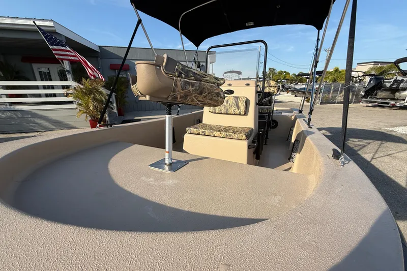 Slide: The Image of 2026 Carolina Skiff E18 JVX CC Sportsman Edition boat with camouflage seating and canopy. - 15