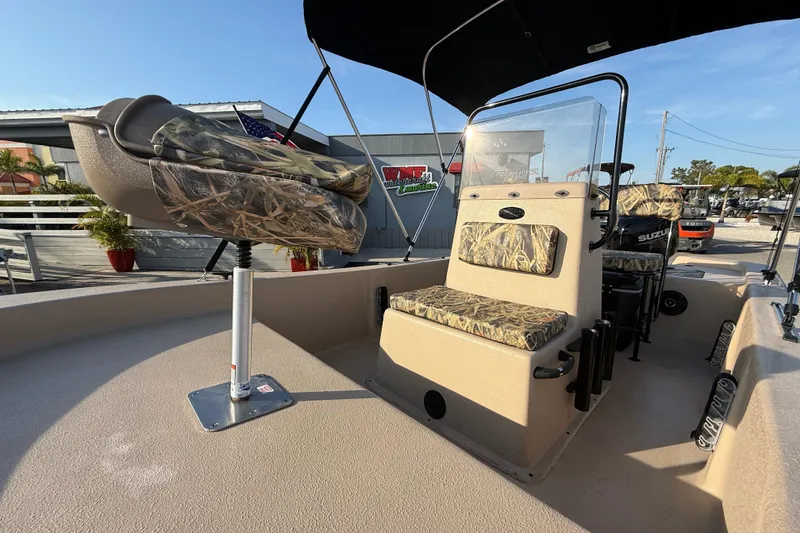 Slide: The Image of 2026 Carolina Skiff E18 JVX CC Sportsman Edition with camo seating and console, outdoor display. - 16
