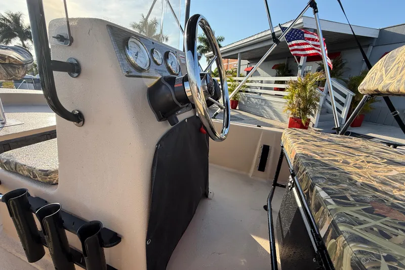 Slide: The Image of 2026 Carolina Skiff E18 JVX CC Sportsman Edition boat interior with camo seats and steering console. - 19