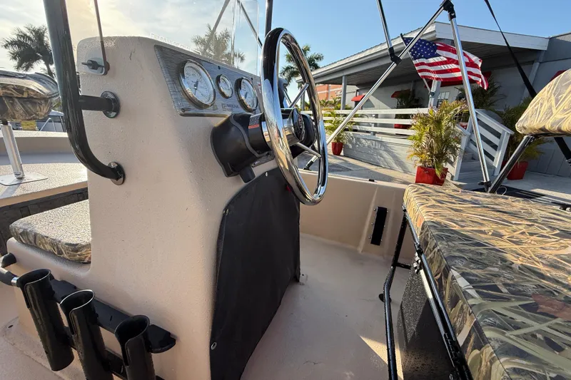 Slide: The Image of 2026 Carolina Skiff E18 JVX CC Sportsman Edition boat interior with steering wheel and camo seats. - 20