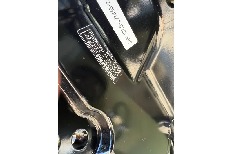 Slide: The Image of Close-up of a 2026 Carolina Skiff E18 JVX CC Sportsman Edition engine part with Suzuki label. - 23