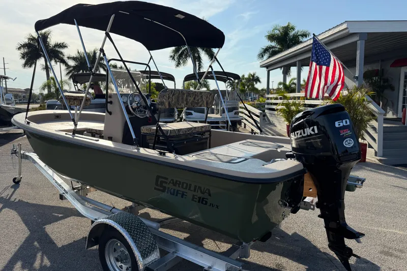 Slide: The Image of 2026 Carolina Skiff E18 JVX CC Sportsman Edition boat on trailer with Suzuki outboard motor. - 9