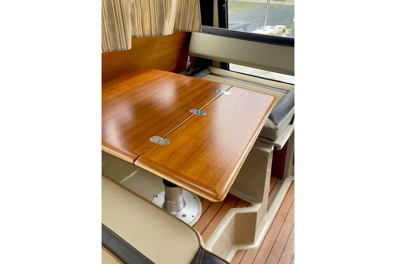 Slide: The Image of Interior of 2018 Ranger Tugs R-27 with wooden table and seating area. - 16