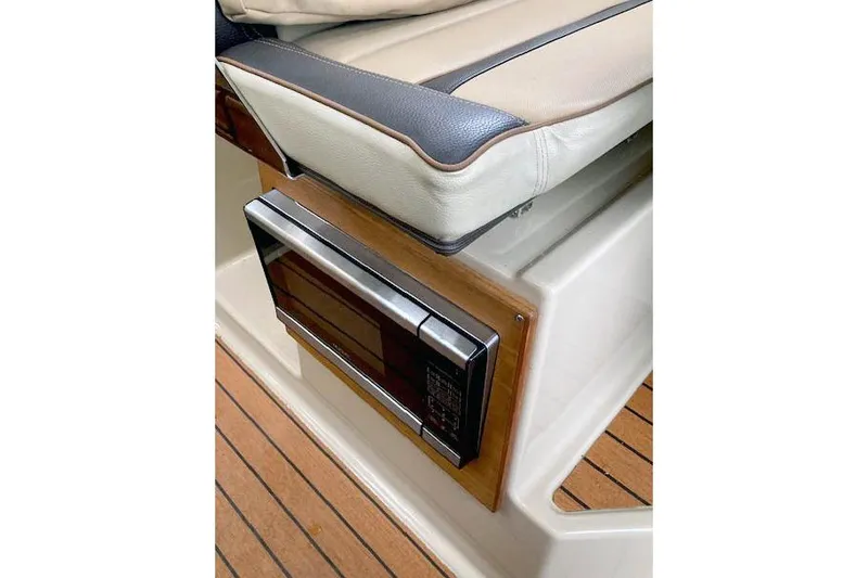 Slide: The Image of 2018 Ranger Tugs R-27 interior with microwave and cushioned seating. - 20