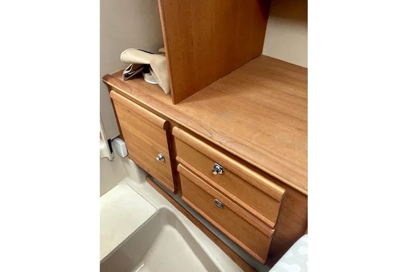 Slide: The Image of 2018 Ranger Tugs R-27 interior with wooden cabinetry and storage drawers. - 21