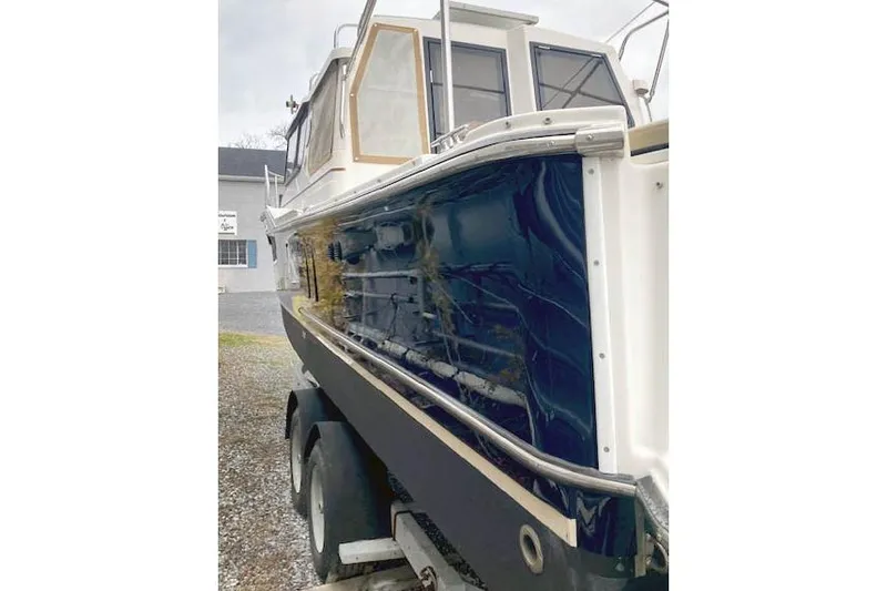 Slide: The Image of 2018 Ranger Tugs R-27 boat on trailer, featuring sleek blue and white design. - 7