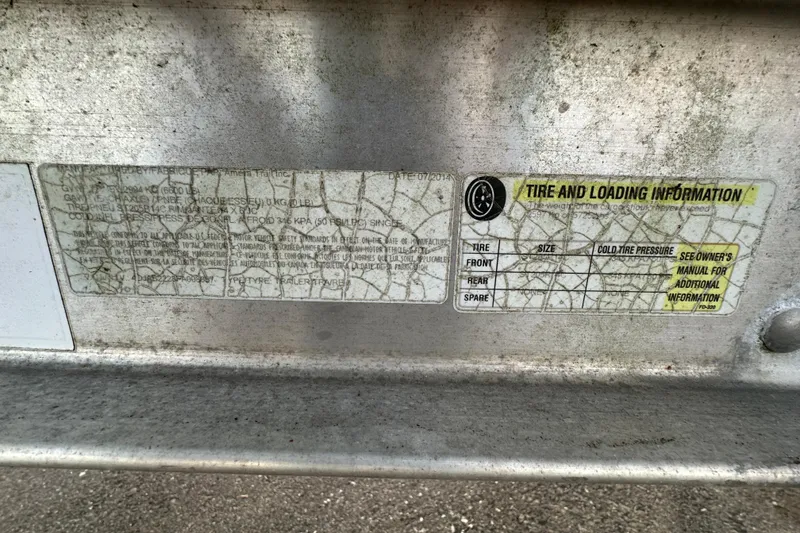 Slide: The Image of 2015 Pathfinder 2200 TRS boat interior with console and seating, parked in a marina. - 15