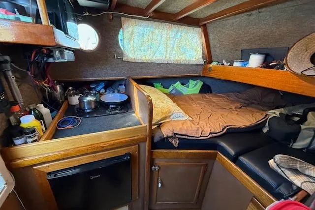 Slide: The Image of Cozy interior of a 1982 Willard Vega 30 boat with a compact kitchen and sleeping area. - 10