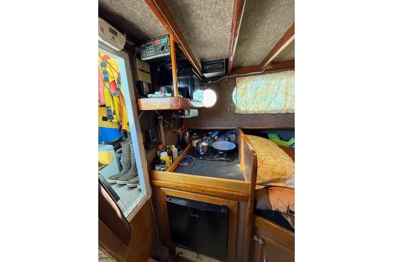 Slide: The Image of Interior of 1982 Willard Vega 30 boat with cozy cabin and kitchenette. - 12