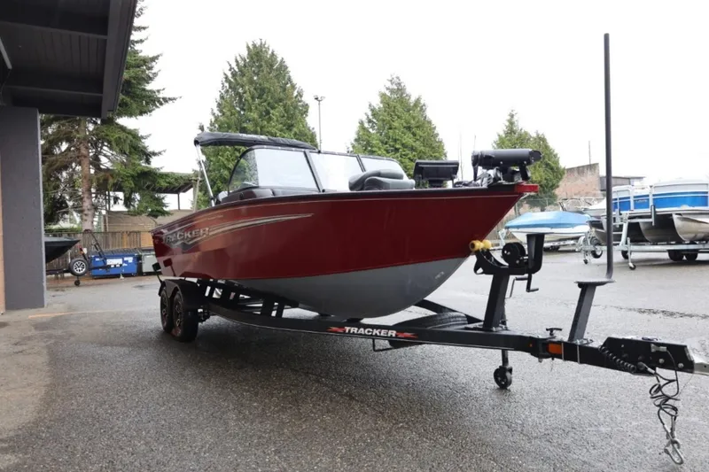 Slide: The Image of 2022 Tracker Targa V-19 Combo Tournament Edition boat on trailer, parked outdoors. - 10