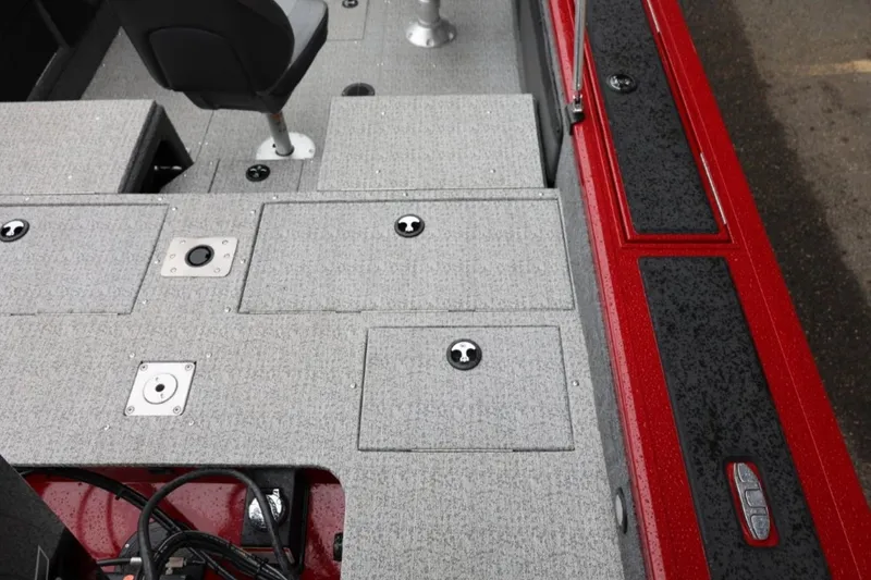Slide: The Image of 2022 Tracker Targa V-19 Combo Tournament Edition boat interior with gray carpet and red accents. - 17