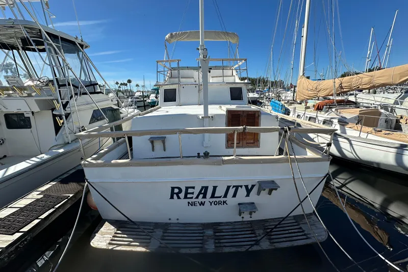 The Image of 1979 Marine Trader 38DC yacht docked, named "Reality," in a sunny marina setting. - 1