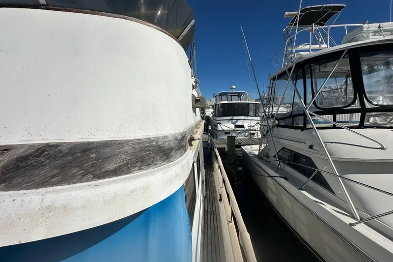 Slide: The Image of 1979 Marine Trader 38DC docked alongside other boats under clear blue sky. - 15