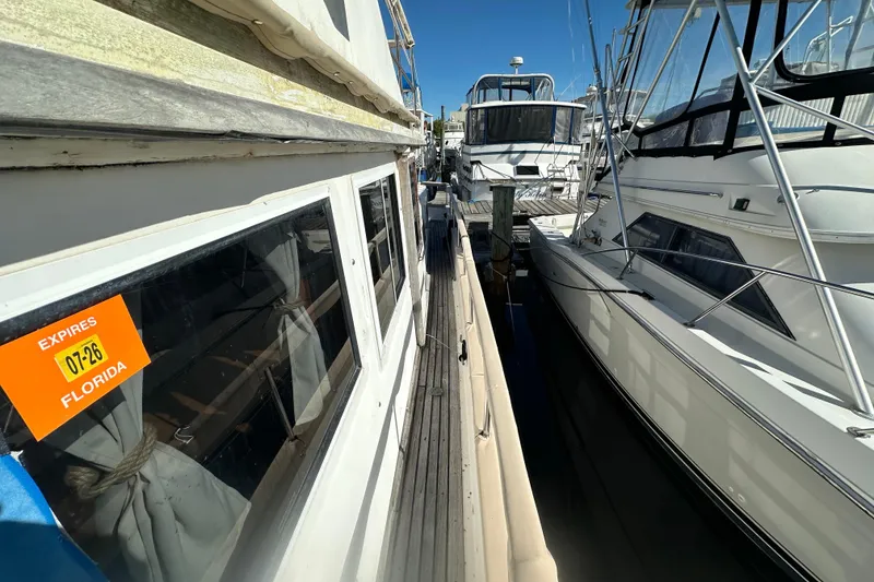 Slide: The Image of 1979 Marine Trader 38DC docked in Florida marina, surrounded by other boats. - 16