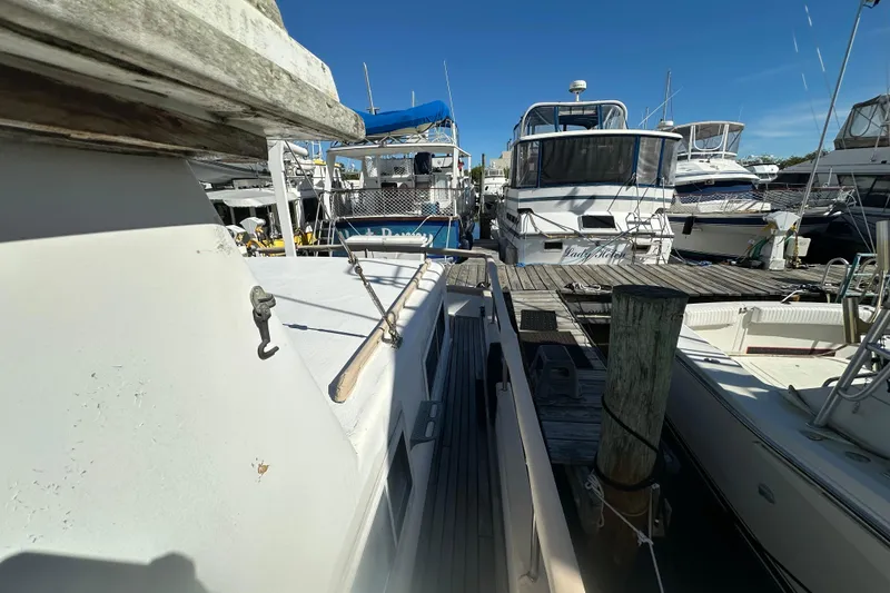 Slide: The Image of 1979 Marine Trader 38DC docked among other boats at a marina. - 17