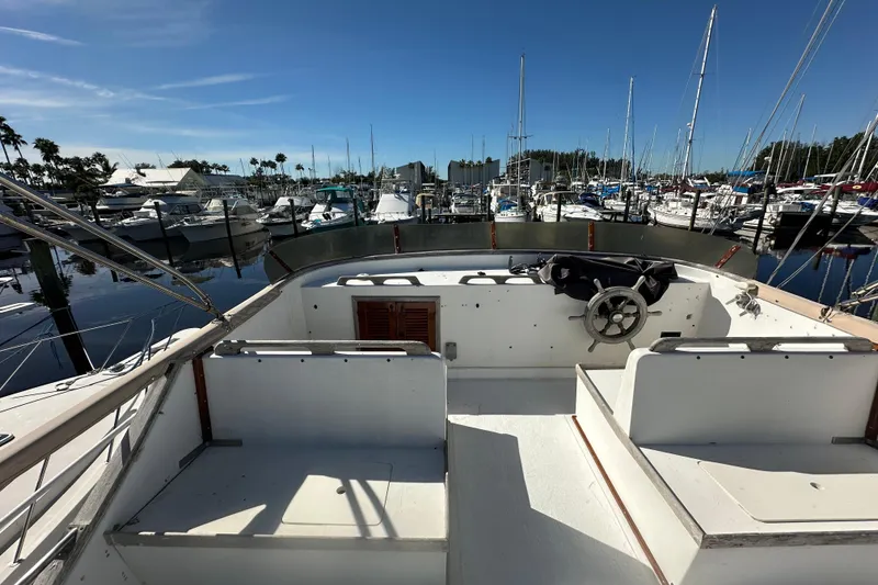 Slide: The Image of 1979 Marine Trader 38DC yacht docked at marina, clear sky, calm waters. - 18