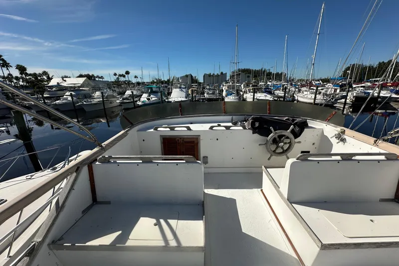 Slide: The Image of 1979 Marine Trader 38DC yacht docked at marina, clear sky, surrounded by boats. - 19