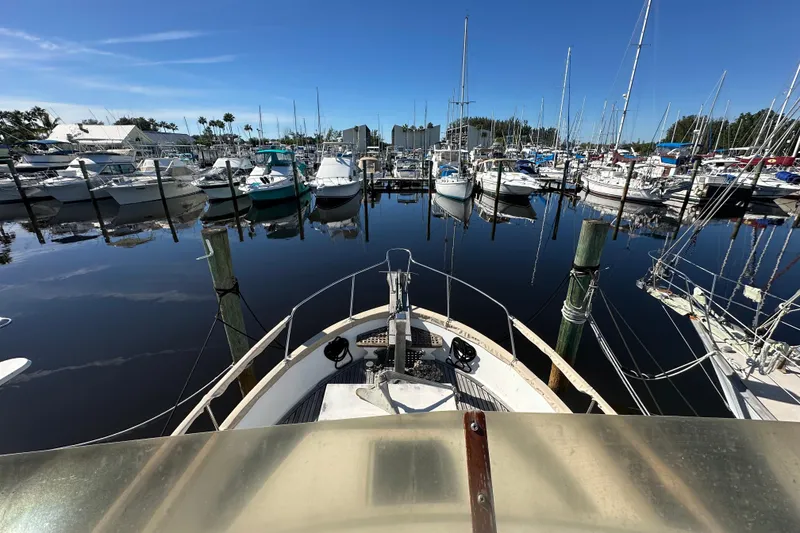Slide: The Image of 1979 Marine Trader 38DC docked in a marina with sailboats and clear blue sky. - 21