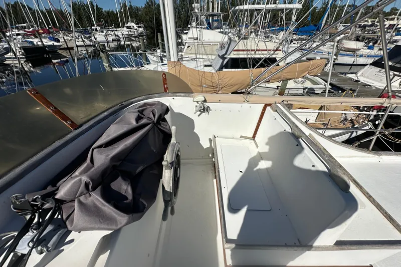 Slide: The Image of 1979 Marine Trader 38DC boat deck with marina view, featuring covered equipment and railing. - 22