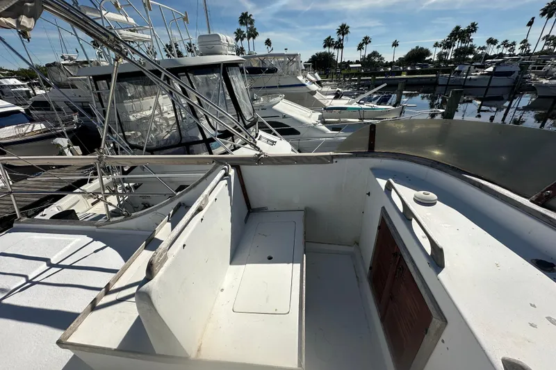 Slide: The Image of 1979 Marine Trader 38DC boat docked in a marina with clear skies and palm trees. - 24