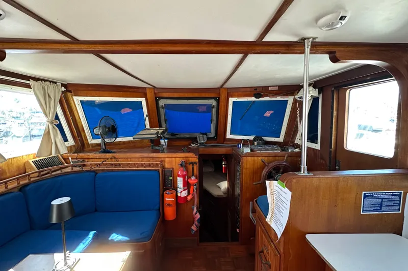 Slide: The Image of 1979 Marine Trader 38DC boat interior with blue seating, wooden accents, and navigation equipment. - 27