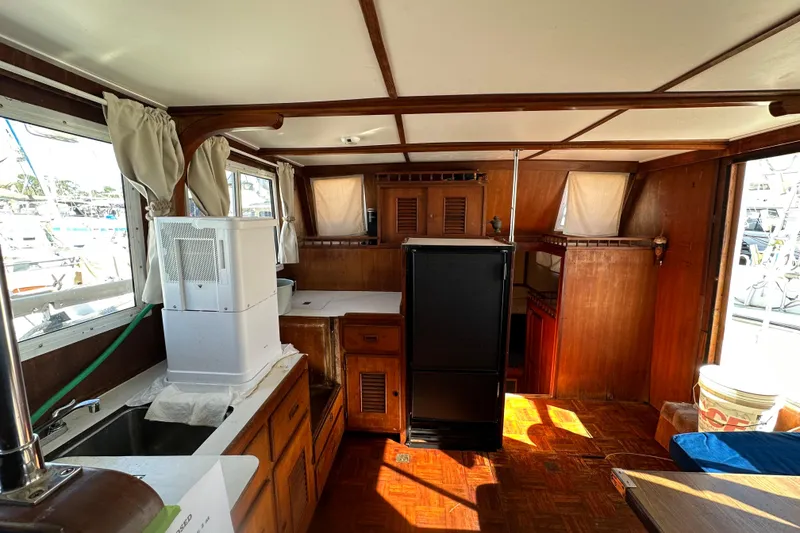 Slide: The Image of 1979 Marine Trader 38DC interior with wood paneling, kitchenette, and windows. - 28