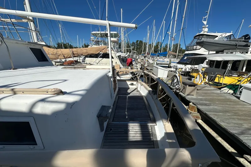 Slide: The Image of 1979 Marine Trader 38DC docked at marina, surrounded by other boats under clear blue sky. - 3
