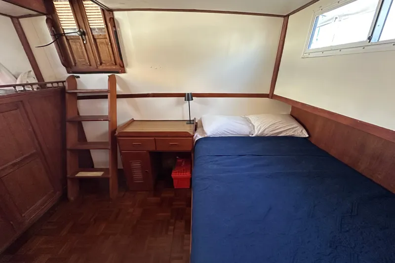 Slide: The Image of Cozy cabin interior of 1979 Marine Trader 38DC with bed, desk, and wooden ladder. - 30