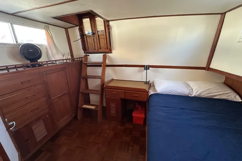 Slide: The Image of 1979 Marine Trader 38DC cabin interior with bed, desk, and wooden storage. - 31