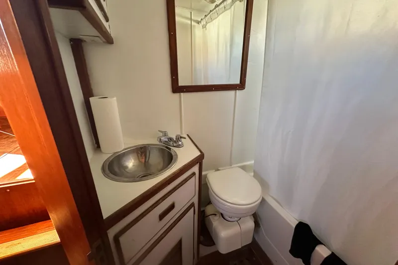Slide: The Image of 1979 Marine Trader 38DC bathroom with sink, toilet, and mirror. - 37