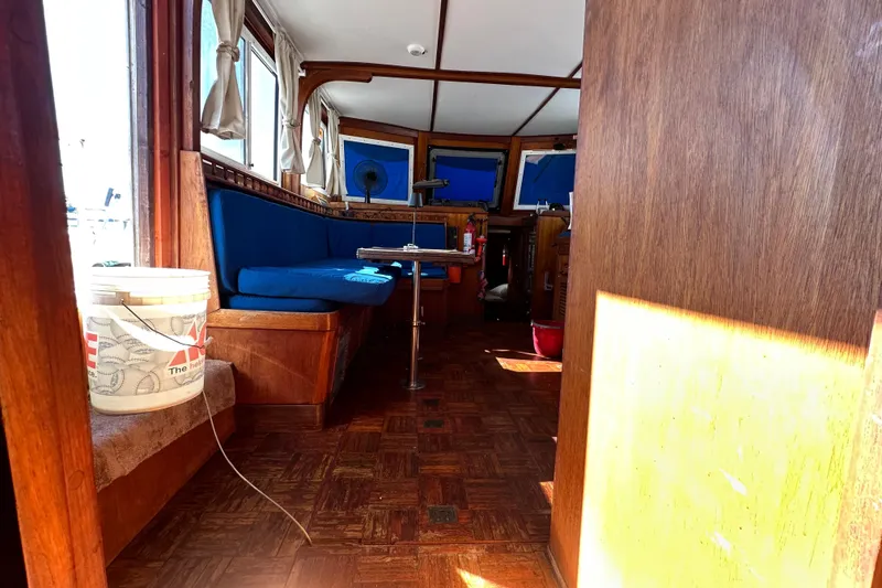 Slide: The Image of Interior of 1979 Marine Trader 38DC boat with blue seating and wooden decor. - 38
