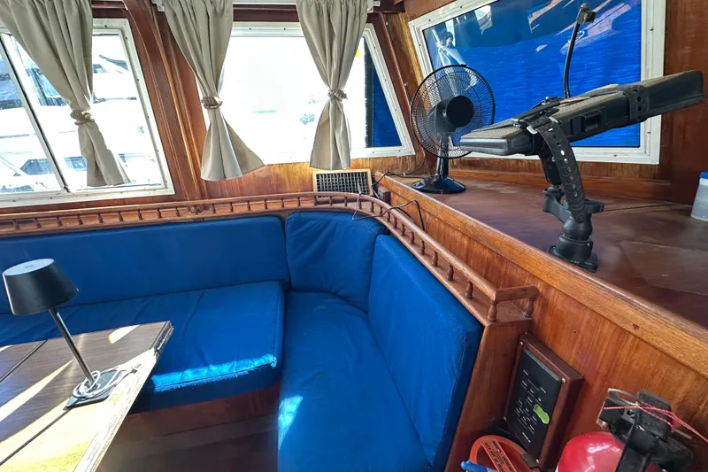 Slide: The Image of Interior of 1979 Marine Trader 38DC with blue seating, wooden accents, and nautical decor. - 41