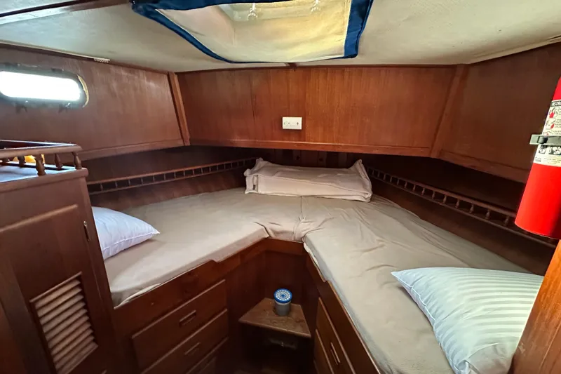 Slide: The Image of 1979 Marine Trader 38DC cabin with wooden interior, bed, and fire extinguisher. - 43