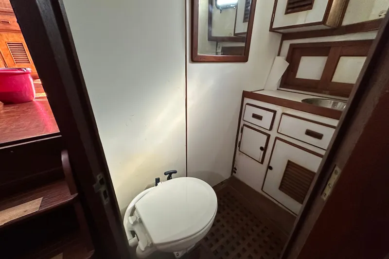 Slide: The Image of 1979 Marine Trader 38DC bathroom with wooden cabinets and toilet. - 45