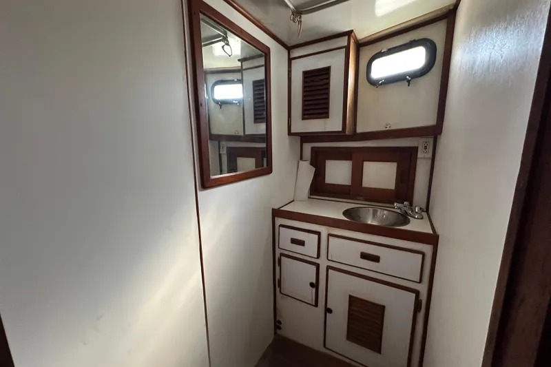Slide: The Image of 1979 Marine Trader 38DC bathroom with wooden cabinets and a small sink. - 47