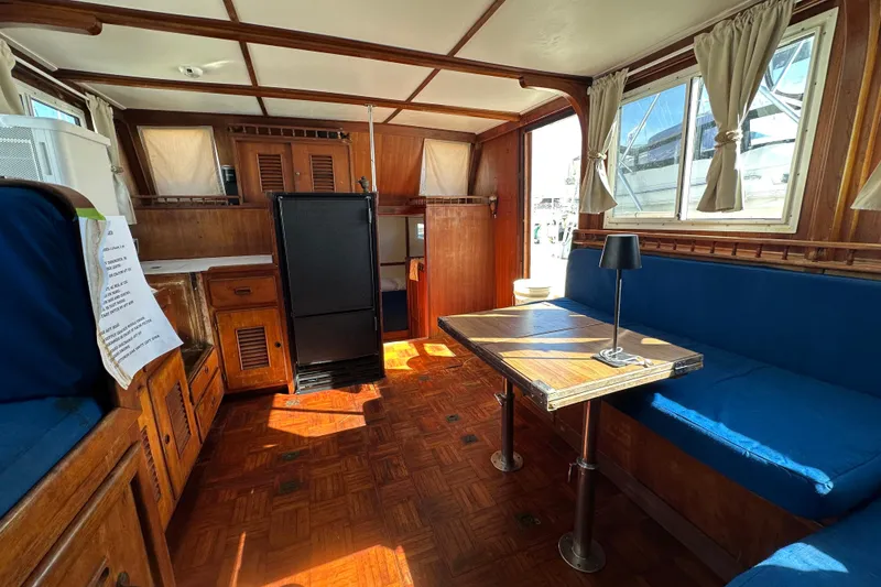 Slide: The Image of 1979 Marine Trader 38DC interior with wood paneling, blue seating, and dining table. - 48