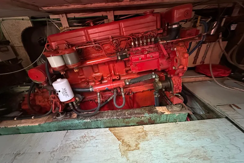 Slide: The Image of 1979 Marine Trader 38DC engine, red, in a boat's engine room. - 53