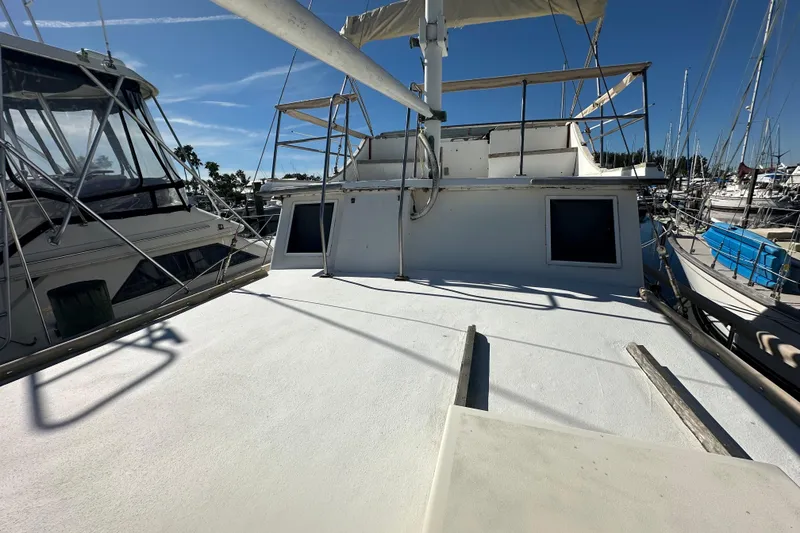 Slide: The Image of 1979 Marine Trader 38DC yacht deck view at marina under clear blue sky. - 6
