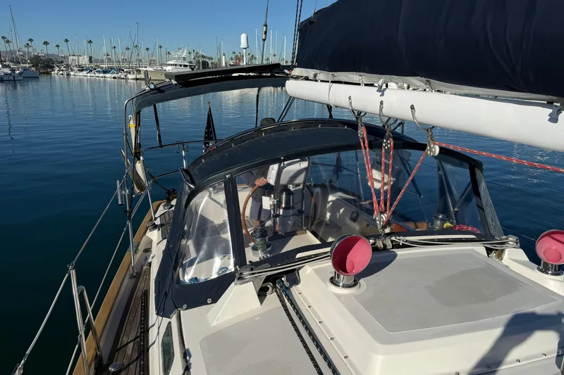 Slide: The Image of 1985 Passport 40 sailboat docked in a marina, clear blue sky, calm water. - 13