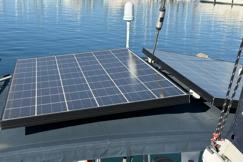 Slide: The Image of Solar panels on a 1985 Passport 40 yacht, reflecting sunlight on calm water. - 15
