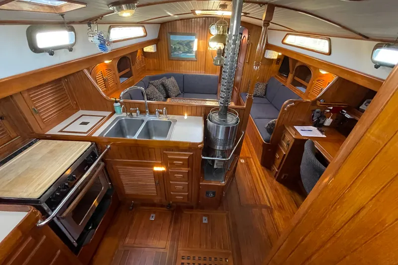 Slide: The Image of Interior of a 1985 Passport 40 sailboat with wood finish and cozy seating area. - 17
