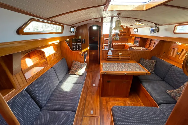Slide: The Image of Luxurious 1985 Passport 40 yacht interior with wooden finish and cozy seating area. - 19