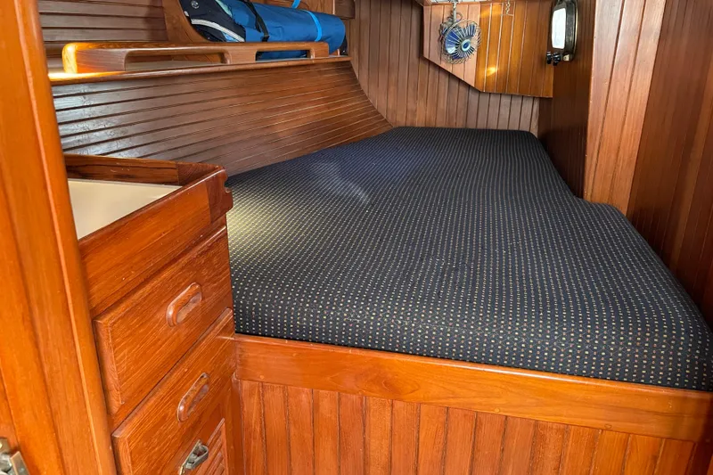 Slide: The Image of Cozy wooden cabin interior of 1985 Passport 40 sailboat with bed and storage. - 24