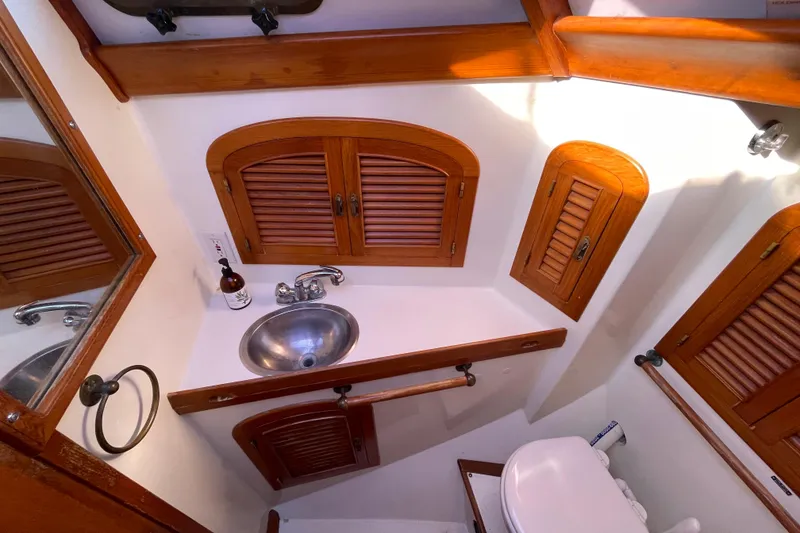 Slide: The Image of Vintage 1985 Passport 40 yacht bathroom with wooden cabinets and stainless steel sink. - 28