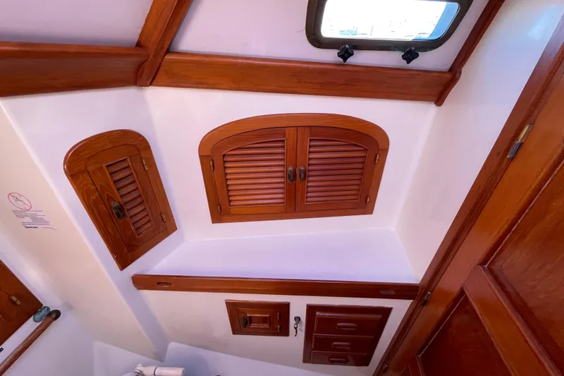 Slide: The Image of Interior of 1985 Passport 40 sailboat with wooden cabinets and porthole. - 29